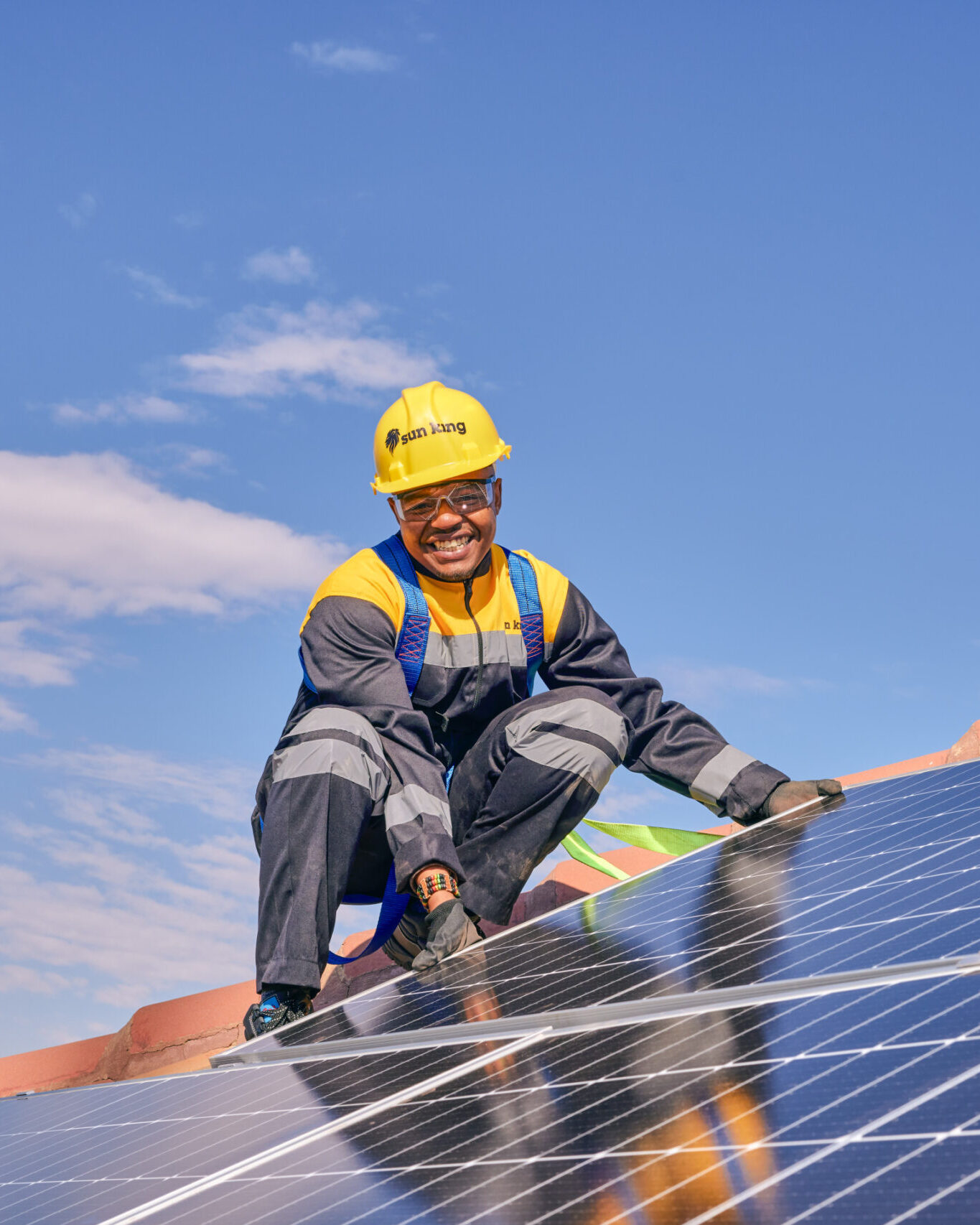 Sun King employee on a roof installing solar panels for a solar inverter system.